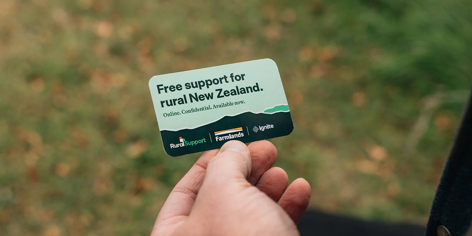 A hand holds a card reading "Free support for rural New Zealand." Logos for Rural Support Trust, Farmlands, and Ignite are visible.