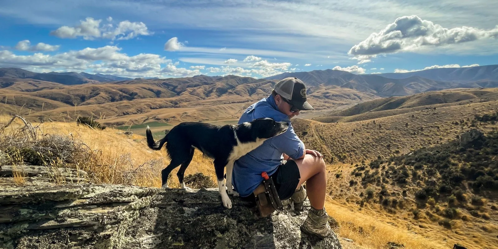 Farmer with a dog overlooking rolling hills