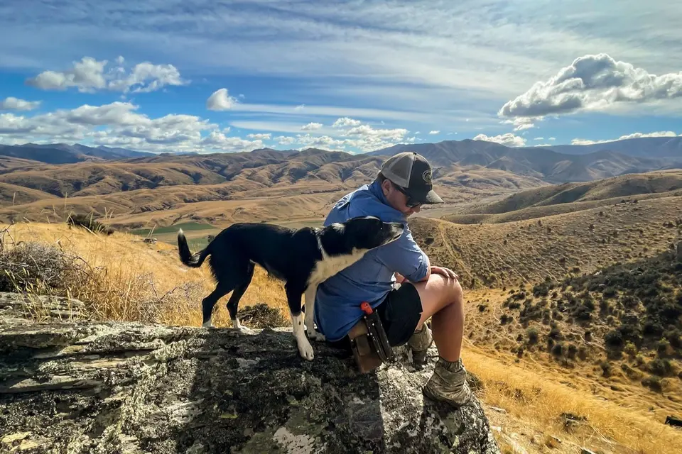Farmer with a dog overlooking rolling hills