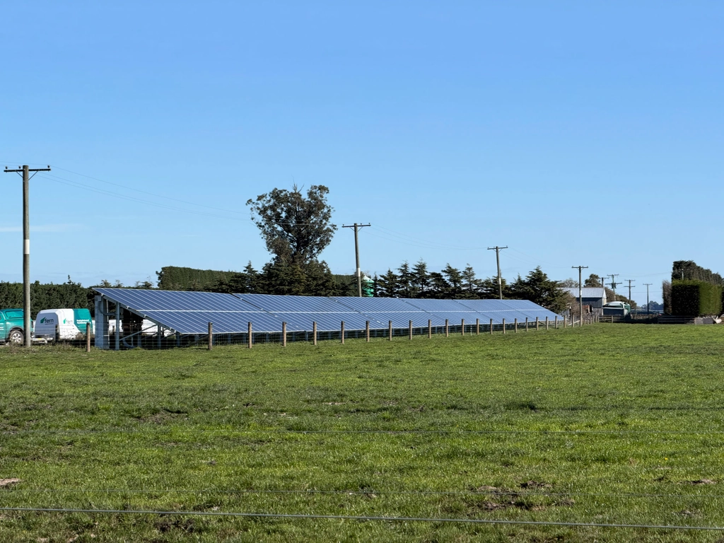 A large row of solar panels at a farm.