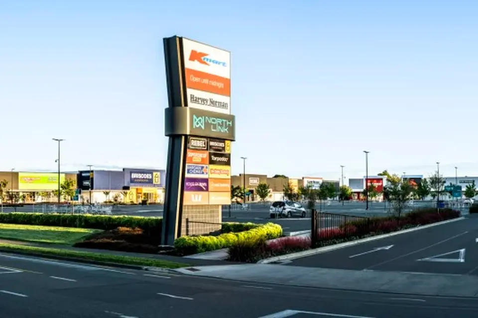 Farmlands rural events: Shopping center entrance with a large sign displaying various store logos. Surrounding area includes a parking lot and